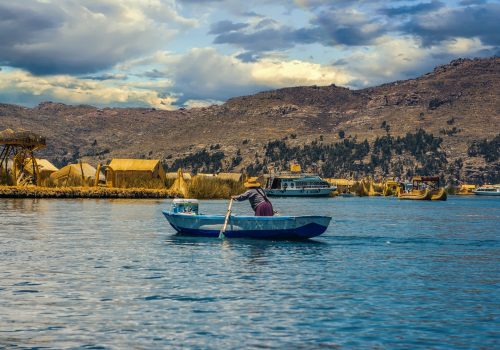 Peruvian,Woman,Rowing,On,A,Boat,,Uros,Island,,Titicaca,Lake,